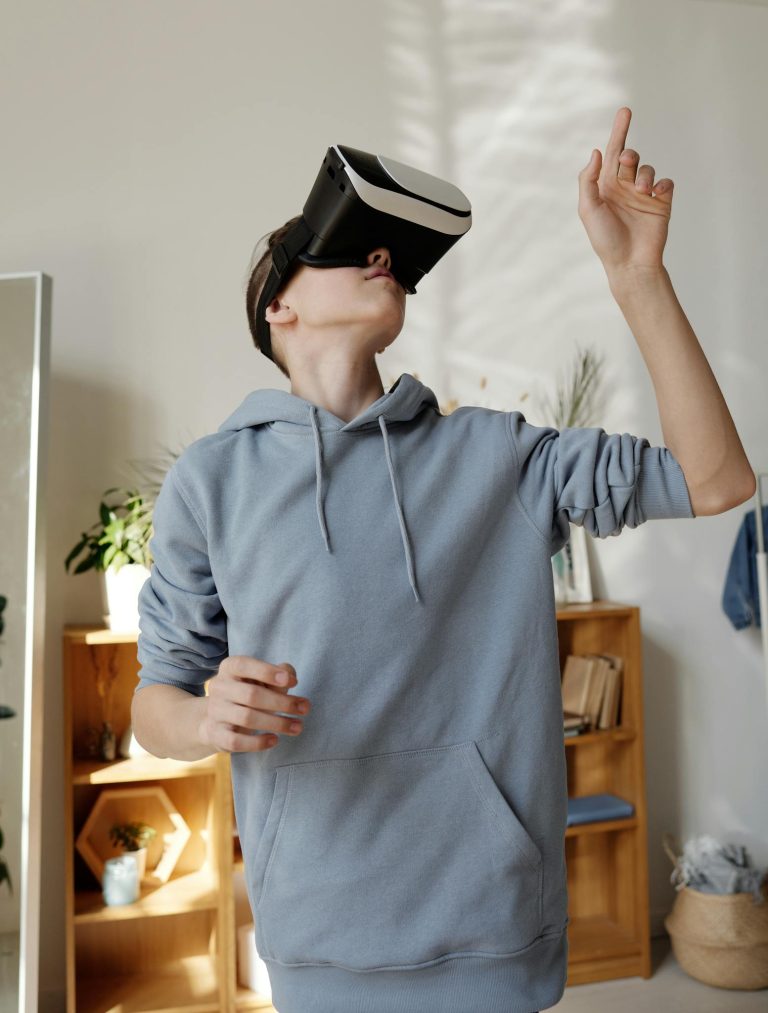 Teenage boy using VR headset indoors, engaging with virtual reality in a cozy room setting.